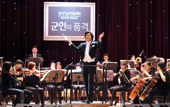 현대자동차그룹은 10일 충남 계룡시 육군본부 대강당에서 정진행 현대자동차 사장, 조정환 육군참모총장과 군 지휘관 및 가족 1000여명이 참가한 가운데 ‘군인의 품격! 토크 콘서트’를 진행했다. 서희태(가운데) 지휘자가 40인조 오케스트라와 함께 ‘클래식과 리더십’을 주제로 강연을 진행하고 있다.