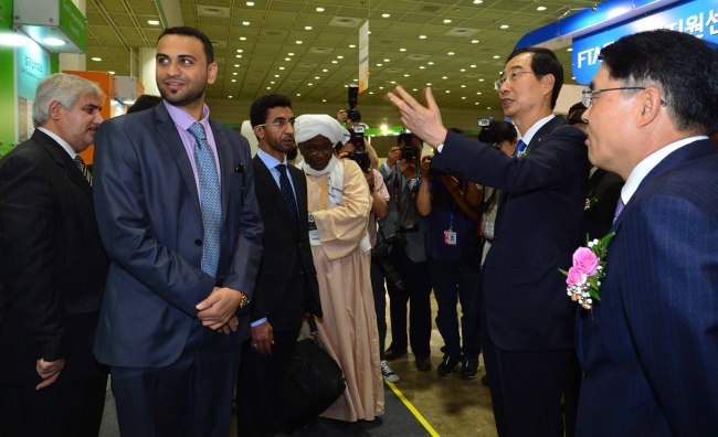 KITA chairman Han Duck-soo (second from right) talks to participants of the Korea Grand Sourcing Fair 2013 at COEX in Seoul on Tuesday.   Lee Sang-sub/The Korea Herald