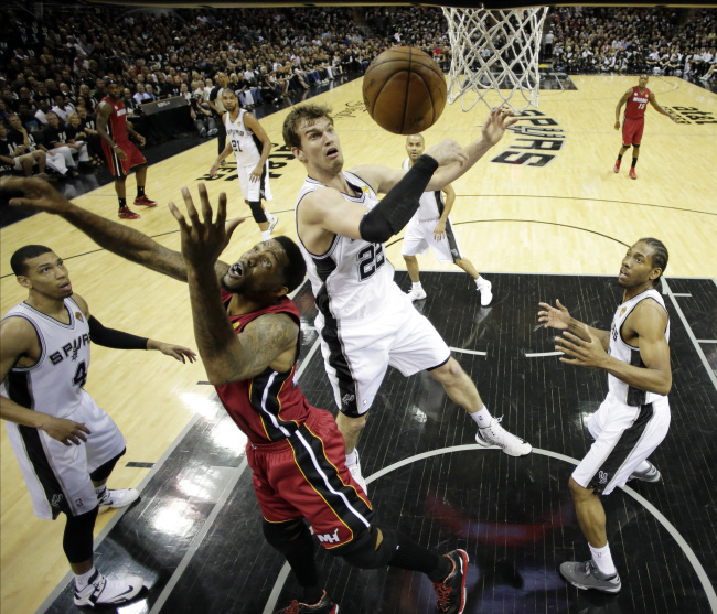 San Antonio Spurs’ Tiago Splitter (second from right) and Miami Heat’s Udonis Haslem battle for a rebound during the first half at Game 3 of the NBA Finals basketball series in San Antonio on Tuesday.   AP-Yonhap News