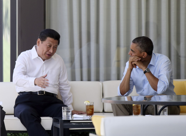 Chinese President Xi Jinping and U.S. President Barack Obama talk on a bench before heading into their second meeting, at the Annenberg Retreat, California, Saturday.   Xinhua-Yonhap News