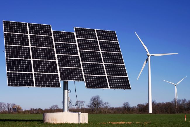 Solar power panels on a wind farm.   123 RF