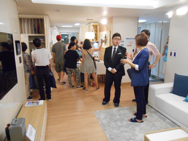 본지 윤현종 기자(오른쪽 세번째)가 14일 서울 마포구 서교동에 개관한 한 견본주택의 1일분양사원으로 변신, 예비 청약자와 상담하는 등 마케팅 활동을 벌이고 있다.