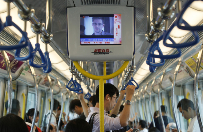 A TV screen shows the news of Edward Snowden, a former CIA employee who leaked top-secret documents about sweeping U.S. surveillance programs, in an underground train in Hong Kong Sunday.   AP-Yonhap News