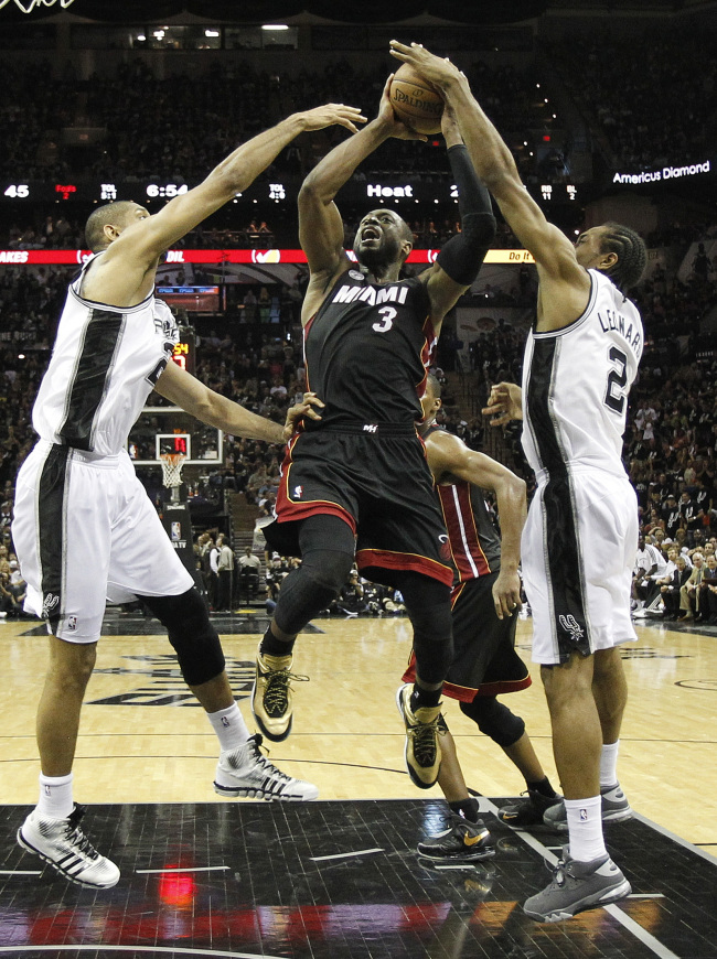 Miami Heat's Dwyane Wade (3) is defended by San Antonio Spurs' Tim Duncan, left, and Kawhi Leonard (2) during the first half at Game 5 of the NBA Finals basketball series, Sunday. (AP-Yonhap News)