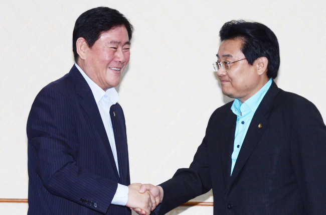 Saenuri Party floor leader Rep. Choi Kyung-hwan (left) and his Democratic Party counterpart Rep. Jun Byung-hun shake hands during talks at the National Assembly on Thursday.   Park Hyun-koo/The Korea Herald