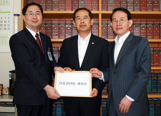 <YONHAP PHOTO-0874> 선플운동본부ㆍ안효대, '선플' 관련법 개정안 제출 (서울=연합뉴스) 새누리당 안효대 의원(가운데)과 ㈔선플운동본부 민병철 이사장(건국대 교수)이 20일 국회사무처에 선플관련법 개정안을 제출하고 있다 사진 왼쪽부터 국회사무처 이정은 의안과장, 안효대 의원, 민병철 이사장. 2013.6.20 photo@yna.co.kr/2013-06-20 13:55:22/ <저작권자 ⓒ 1980-2013 ㈜연합뉴스. 무단 전재 재배포 금지.>
Saenuri Party lawmaker Ahn Hyo-dae (center) and Sunfull founder Min Byoung-chul (right) pose with Lee Jung-eun, an official of the National Assembly Secretariat, as they submit “Sunfull” bills against malicious online comments to the secretariat on Thursday.   Yonhap News