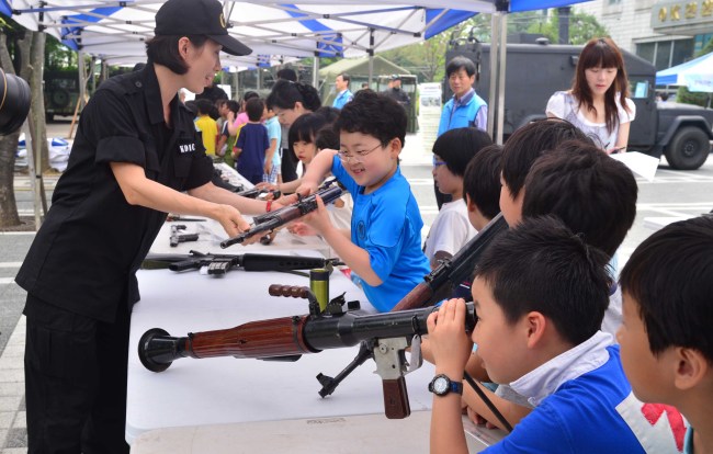 Children look at South Korean and North Korean military equipment at a national security exhibition organized to teach children about the horrors of war in Seoul on Friday.   Lee Sang-sub/The Korea Herald