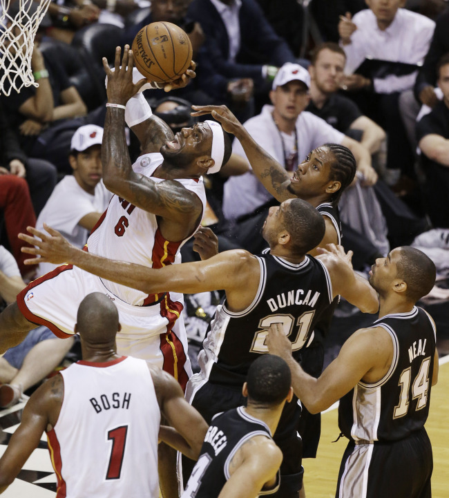 Miami Heat's LeBron James (6) goes by San Antonio Spurs' Kawhi Leonard (2) and Tim Duncan (21) for a shot during the first half in Game 7 of the NBA basketball championships, Thursday. (AP-Yonhap News)