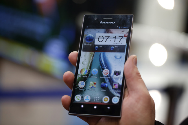 An employee displays a Lenovo K900 smartphone at the Mobile World Congress in Barcelona.   Bloomberg
