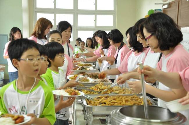 Children line up for lunch at last year’s Mustard Seed English Camp.   Brad Curtin