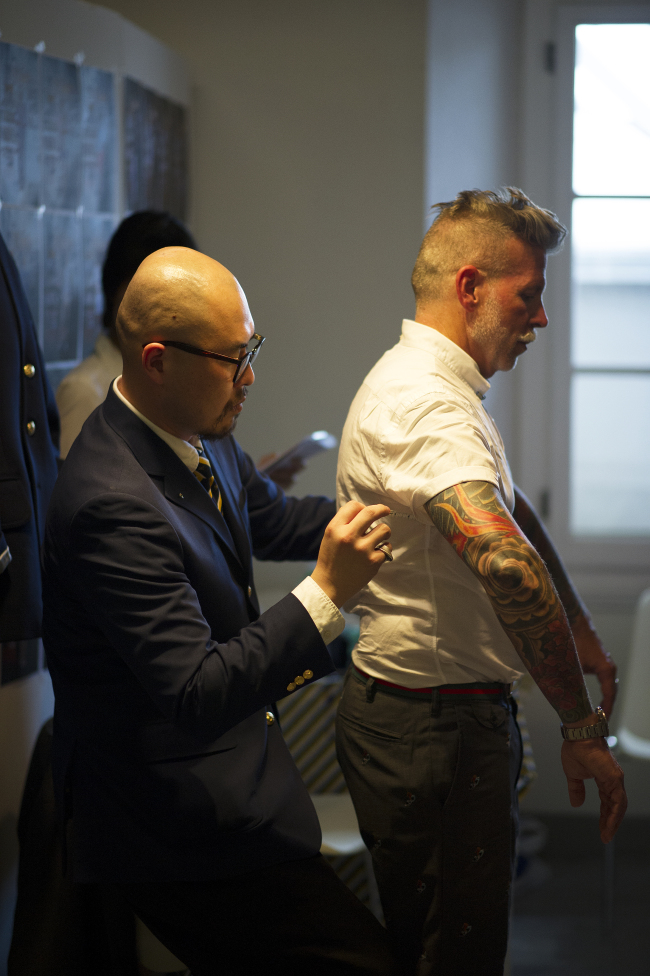 Ji Il-geun, head designer of menswear brand Instantology, makes a fit adjustment for celebrated buyer Nick Wooster.   Korea Creative Content Agency