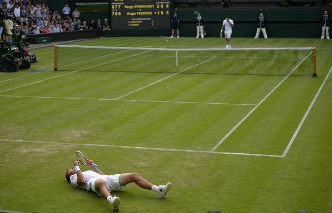 Ukraine's Sergiy Stakhovsky (on the floor) celebrates beating Switzerland's Roger Federer (top) in their second round men's singles match on day three of the 2013 Wimbledon Championships tennis tournament at the All England Club in Wimbledon, southwest London, on Wednesday. (AFP-Yonhap News)