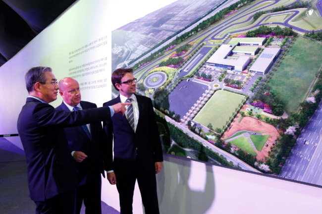 BMW Korea CEO Kim Hyo-joon (left) introduces a driving center to be built on Yeongjongdo Island off Incheon to BMW Group’s executives on June 4.   BMW Korea