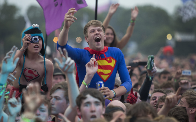 A man dressed as Superman watches Dizzee Rascal perform on the Pyramid main stage at Glastonbury, England, Friday. Thousands of music fans have arrived for the festival to see headliners Arctic Monkeys, Mumford and Sons and the Rolling Stones.   AP-Yonhap News