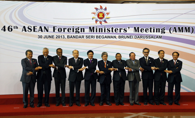 Foreign ministers of Southeast Asian nations hold hands as they pose for a group photo during the opening ceremony of the 46th ASEAN Foreign Ministers’ Meeting in Bandar Seri Begawan on Sunday.   AP-Yonhap News