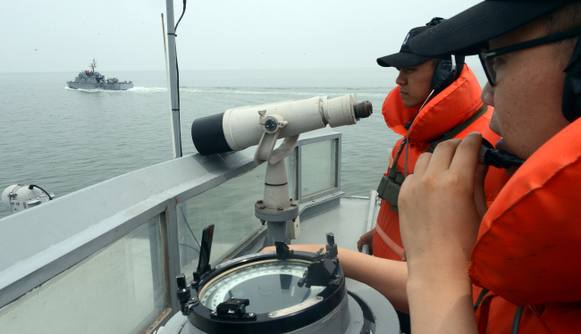 Navy troops stand guard on the Chamsuri-361 warship during their patrol mission near the Northern Limit Line, the de facto maritime border with North Korea, last week.  Ahn Hoon/The Korea Herald