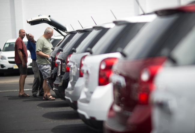 People browse through rows of cars for sale at the Jack Maxton Chevrolet dealership in Columbus, Ohio.   Bloomberg