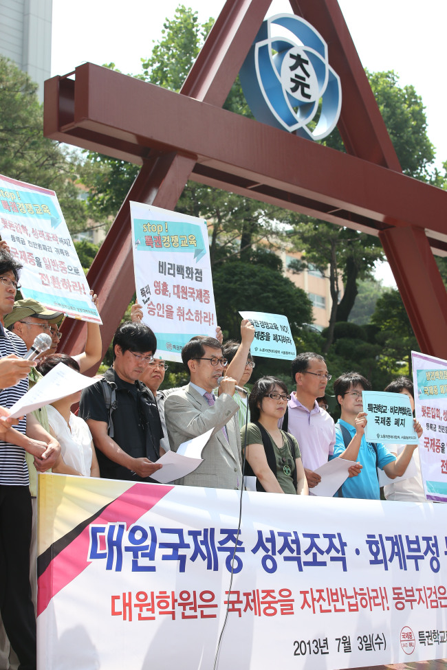 Civic activists hold a rally in front of Daewon International Middle School in Seoul on Wednesday in protest of alleged admission and accounting fraud involving its officials.   Yonhap News