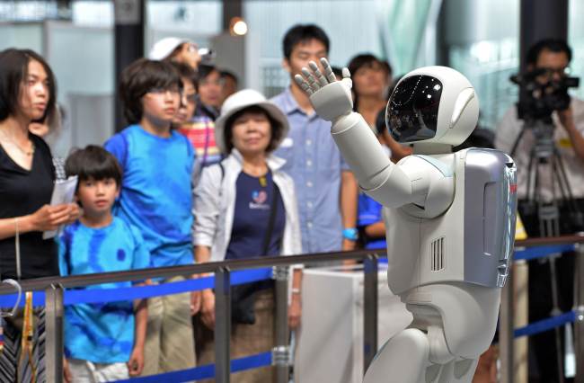Honda Motor’s humanoid robot Asimo interacts with visitors at the National Museum of Emerging Science and Innovation in Tokyo on Wednesday.   AFP-Yonhap News