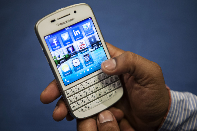 A BlackBerry India employee uses a BlackBerry Q10 smartphone after a news conference for the product’s India launch in New Delhi on June 6.   Bloomberg
