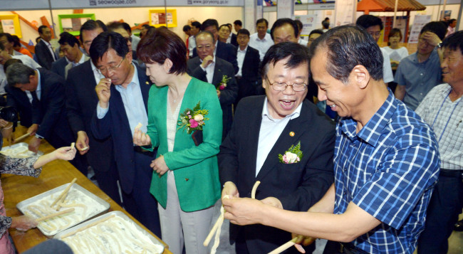 Agriculture Minister Lee Dong-phil (second from right) and Gangwon Gov. Choi Moon-soon (right) participate in the festival promoting tourism in rural and fishing villages that kicked off on Thursday at KINTEX in Goyang, Gyeonggi Province.   Kim Myung-sub/The Korea Herald