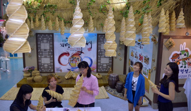 Visitors attend a special straw art class during the ongoing K-Festival 2013 at the Seoul Trade Exhibition & Convention on Friday. SETEC features a variety of programs, including arts and crafts sessions, performances and travel packages, that are offered by some 100 different festivals held at home and abroad. It runs until July 8.   Kim Myung-sub/The Korea Herald