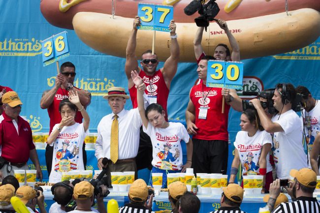 Sonya Thomas (center) wins the Nathan’s Famous Fourth of July International Hot Dog Eating contest at Coney Island in the Brooklyn borough of New York on Thursday.   AP-Yonhap News