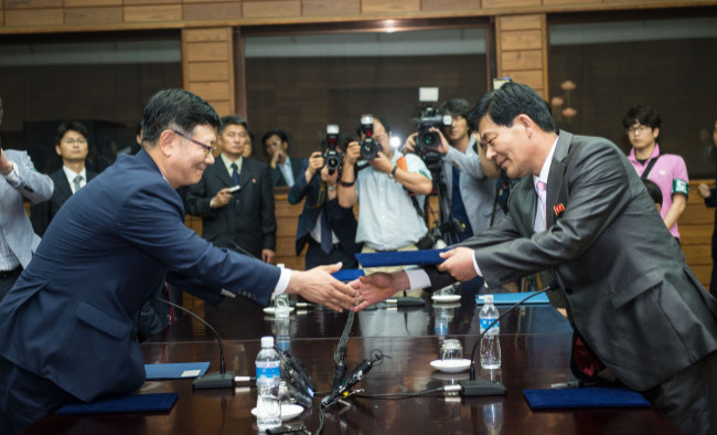 남북 당국간실무회담 우리 측 수석대표인 서호 통일부 남북협력지구지원단장(왼쪽)과 북측 수석대표인 박철수 중앙특구개발지도총국 부총국장이 7일 오전 판문점 북측지역 통일각에서 16시간에 걸친 마라톤 협상 끝에 열린 개성공단 실무회담 종료회의에서 개성공단 정상화 조치 등의 내용을 담은 합의문을 교환하고 있다. (연합뉴스)