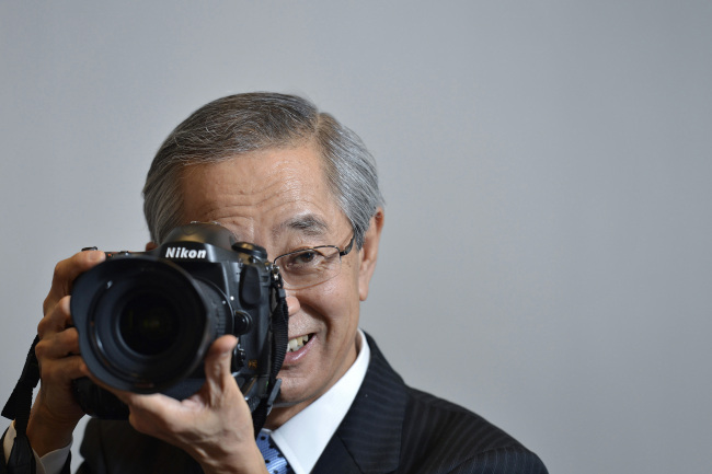 Makoto Kimura, president of Nikon Corp., holds a Nikon D4 digital single-lens reflex camera as he poses for a photograph at the company’s head office in Tokyo on July 4.   Bloomberg