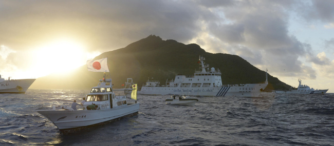 A Chinese surveillance ship (rear center) sails near Uotsuri Island in Japanese, or Diaoyu Dao in Chinese, the biggest of the disputed Senkaku Islands, or Diaoyu Islands, on Juy 1.   AP-Yonhap News