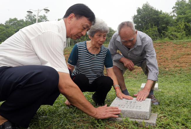 <YONHAP PHOTO-0913> 적군묘지 찾은 첫 중국인 참전용사 (파주=연합뉴스) 임병식 기자 = 중국인 한국전쟁 참전용사 량덩가오(왼쪽부터), 천러뷔, 라이쉐시앤 씨가 9일 오전 경기도 파주시 적성면 답곡리 적군묘지를 방문해 묘비를 쓰다듬고 있다. 2013.7.9 andphotodo@yna.co.kr/2013-07-09 13:16:31/ <저작권자 ⓒ 1980-2013 ㈜연합뉴스. 무단 전재 재배포 금지.>
Three Chinese veterans of the Korean War, Liang Deng Gao (left), Chen Ruo Bi (center) and Lai Xuex Ian, touch a gravestone at a cemetery for Chinese and North Koreans who died in the Korean War in Paju, Gyeonggi Province, Tuesday.   Yonhap News