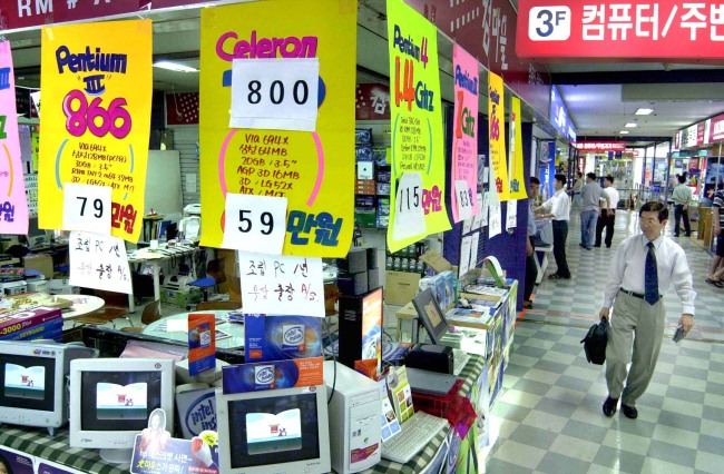 A man walks past a shop selling personal computers in Seoul.   The Korea Herald