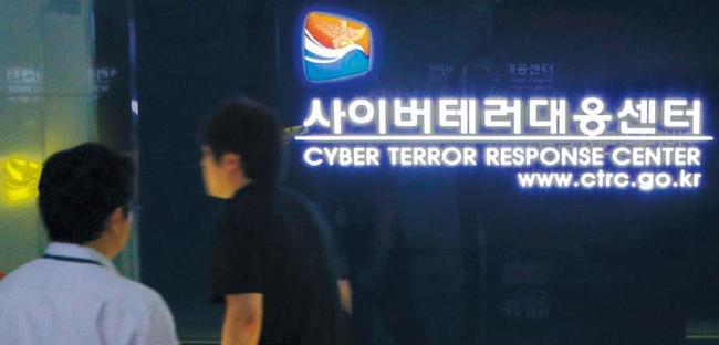 Two men walk by a sign at the Cyber Terror Response Center of the National Police Agency in Seoul. (Yonhap News)