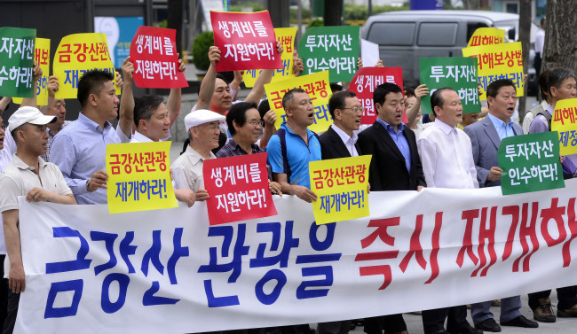 Members of the association of business operations at the Mount Geumgang resort hold a rally in Seoul on Thursday calling for the resumption of the inter-Korean tour program suspended since 2008.   Park Hae-mook/The Korea Herald