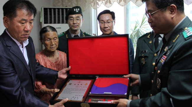 An Army officer hands over the remains of Jung Cheol-ho to his family members in Ulsan on Thursday. Yonhap News