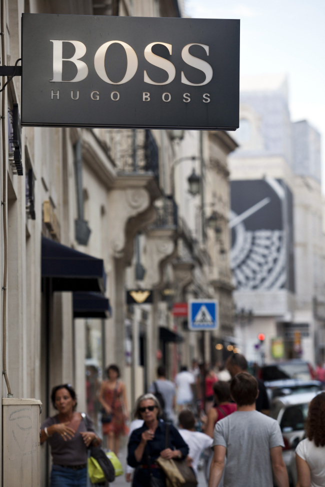 Shoppers pass the Hugo Boss AG store in Paris.    Bloomberg