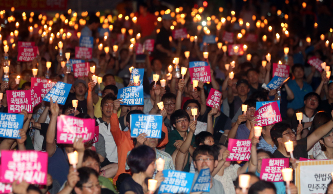 Members of civic groups hold a candlelight vigil to protest the National Intelligence Service’s alleged interference in the presidential election last year at Seoul Plaza on Saturday.    Yonhap News
