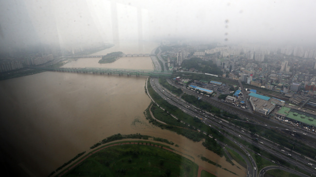 Muddy water fills the Han River after heavy rainfall hit the capital over the weekend.   Yonhap News
