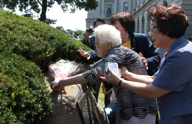 Yi Ok-seon, a former South Korean comfort woman, places flowers at a monument honoring the women forced by Japan into sexual slavery for its troops during World War II, in Bergen County, New Jersey, Monday.   Yonhap News