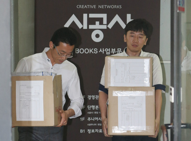 Investigators carry boxes of seized material from publishing company Shigongsa in Seoul, which owned by former President Chun Doo-hwan’s eldest son Jae-kook, on Tuesday.   Yonhap News