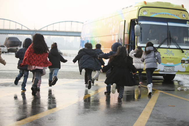 Kids run toward the newly created “Moving Arts Bus.”   Ministry of Culture, Sports and Tourism