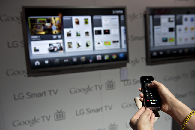 A product demonstrator uses a remote control to navigate a menu on an LG Smart TV with Google TV at the 2012 International Consumer Electronics Show in Las Vegas, Nevada.   Bloomberg