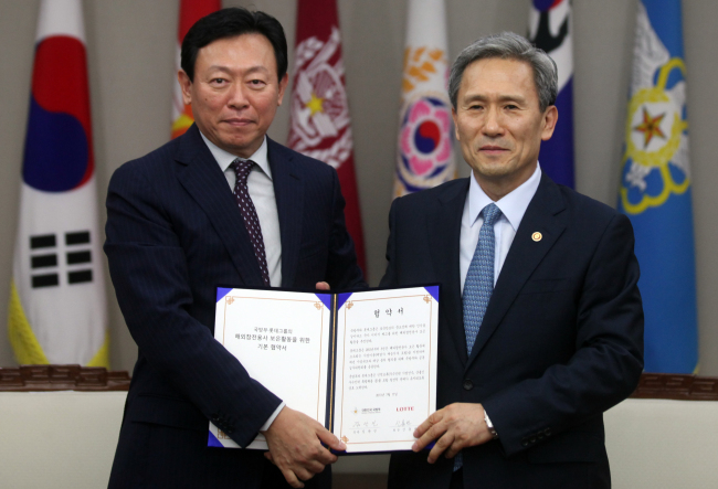 Minister of National Defense Kim Kwan-jin (right) and Lotte Group chairman Shin Dong-bin pose after signing an agreement on projects for Korean War veterans at the ministry headquarters in Seoul on Wednesday.   Yonhap News