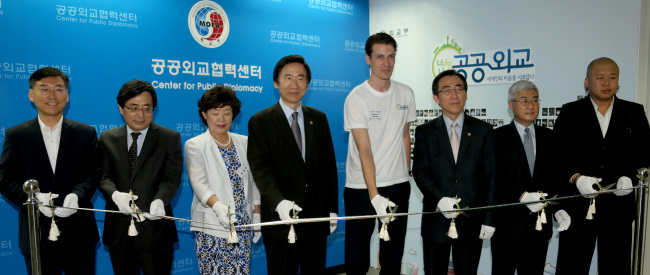 Foreign Minister Yun Byung-se (fourth from left) and other officials cut the tape in a ceremony to open the Center for Public Diplomacy in the ministry in Seoul on Wednesday. From left are Han Choong-hee, director-general for cultural affairs; Shin Dong-ik, deputy minister for multilateral and global affairs; Kim Yang-ja, a member of the senior public diplomatic corps; Yun; Jeroen Tonnon, a Dutch student at Korea University; Cho Tae-yul, vice foreign minister; Ma Young-sam, ambassador for public diplomacy; and Kim Min-soo, a singer and songwriter.   Yonhap News