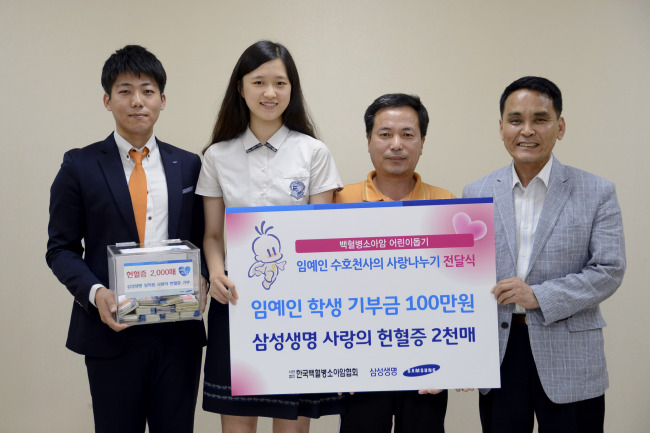임예인(왼쪽 두번째) 학생이 미술 공모전 상금 전액을 소아암 환자 백수환 군에게 전달한 후 백 군 아버지(왼쪽 세번째) 등과 기념촬영을 하고 있다. [사진제공=삼성생명]