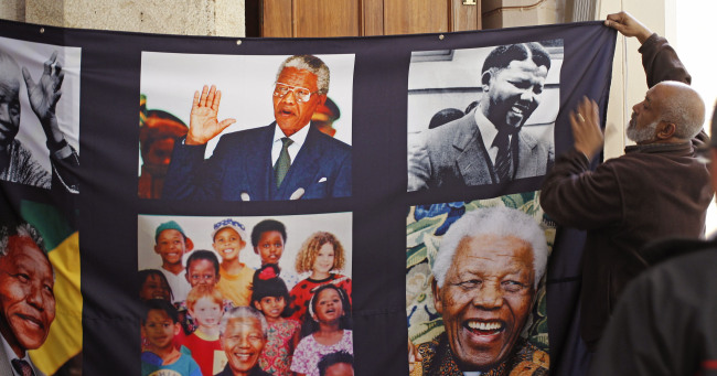 A banner with images of former South African president Nelson Mandela is hung inside St. George’s Cathedral in Cape Town, South Africa, Wednesday.    AP-Yonhap News