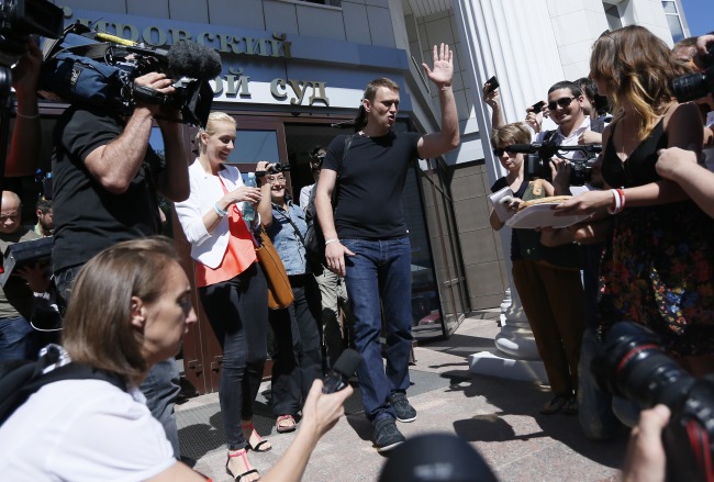 <YONHAP PHOTO-1403> Russian opposition leader Alexei Navalny, center right, and his wife Yulia, center left, greet journalists and supporters as he was released in a courtroom in Kirov, Russia on Friday, July 19, 2013.A Russian court on Friday released opposition leader Alexei Navalny from custody less than 24 hours after he was convicted of embezzlement and sentenced to five years in prison.The release came after a surprise request by prosecutors, who said that because Navalny is a candidate in this fall?s Moscow mayoral race keeping him in custody would deny him his right to seek election. (AP Photo/Dmitry Lovetsky)/2013-07-19 17:31:20/ <저작권자 ⓒ 1980-2013 ㈜연합뉴스. 무단 전재 재배포 금지.>
Russian opposition leader Alexei Navalny (center right) and his wife Yulia (center left) greet journalists and supporters as he was released in a courtroom in Kirov, Russia, Friday.   AP-Yonhap News