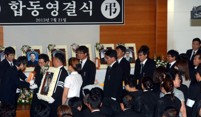 21일 오전 서울 구로동 고대구로병원에서  노량진 배수지 수몰.사고 희생자 7명에 대한 합동 영결식이 열리고  있다./안훈기자  rosedale@ 2013.07.21
A relative carries the portrait of one of seven workers killed in a flash flood on July 15 at a construction site in southern Seoul, at a joint funeral service at the Korea University Guro Hospital in Seoul on Sunday.   Ahn Hoon/ The Korea Herald