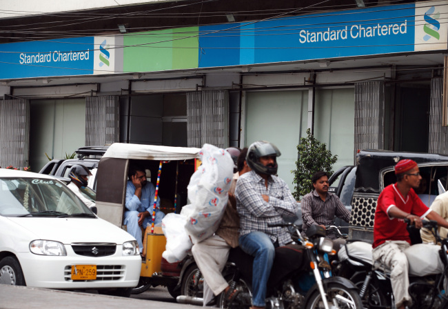 Traffic moves past a Standard Chartered bank branch in Karachi, Pakistan.  Bloomberg