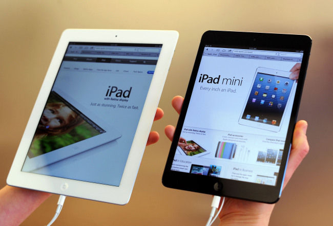An employee displays iPad mini (right) and 4G iPad models at an Apple Inc. store in San Francisco, California.   Bloomberg